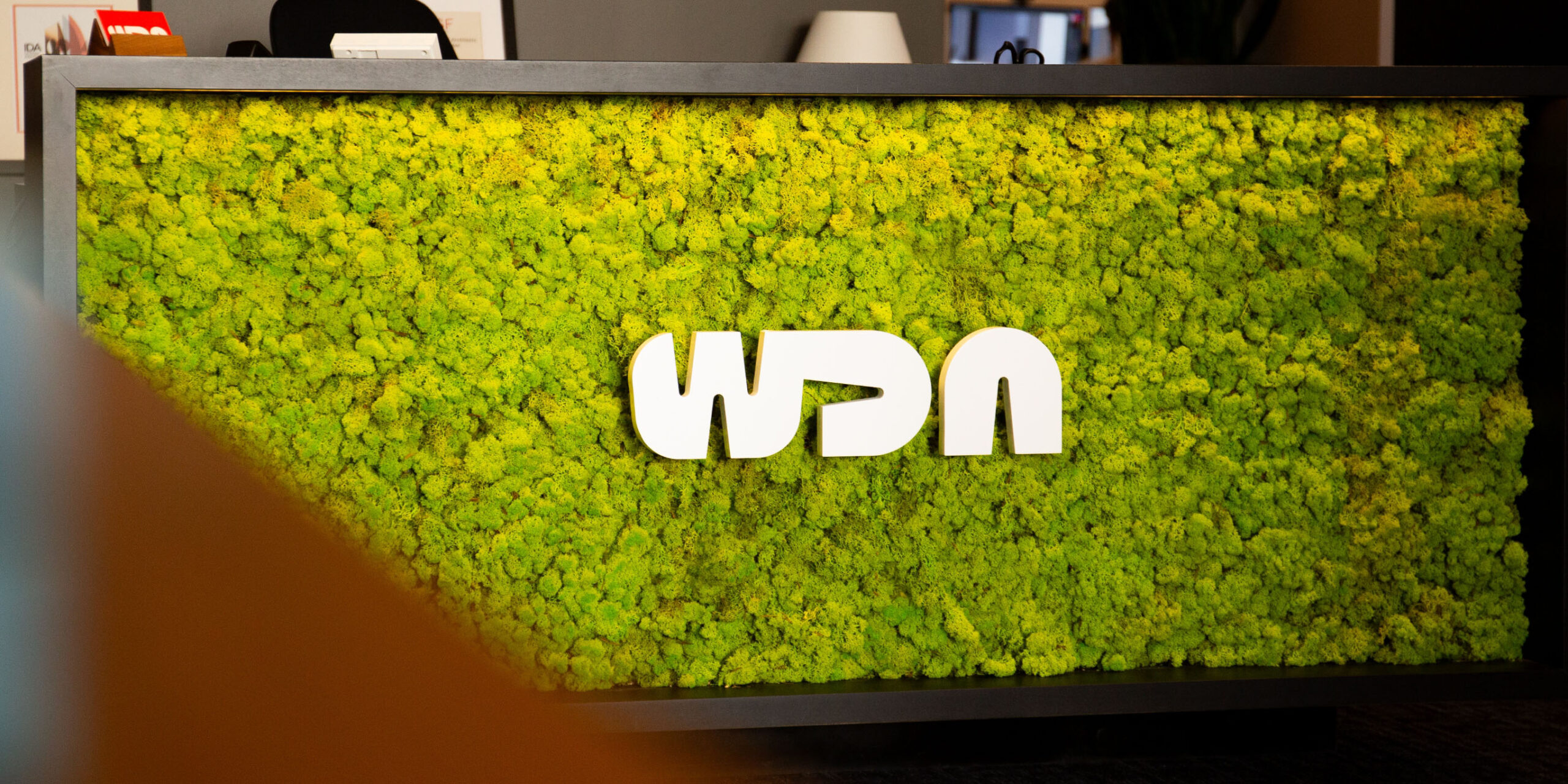 lobby front desk logo signage surrounded by foliage